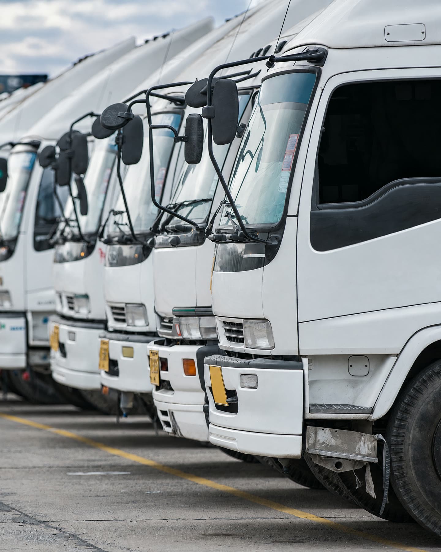 Row of white trucks parked in a depot