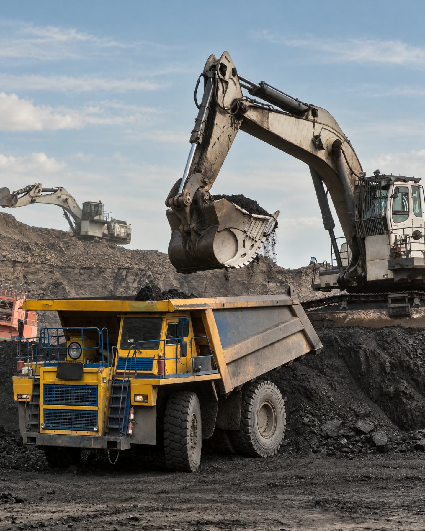 Excavator loading a dump truck at an open-pit mine