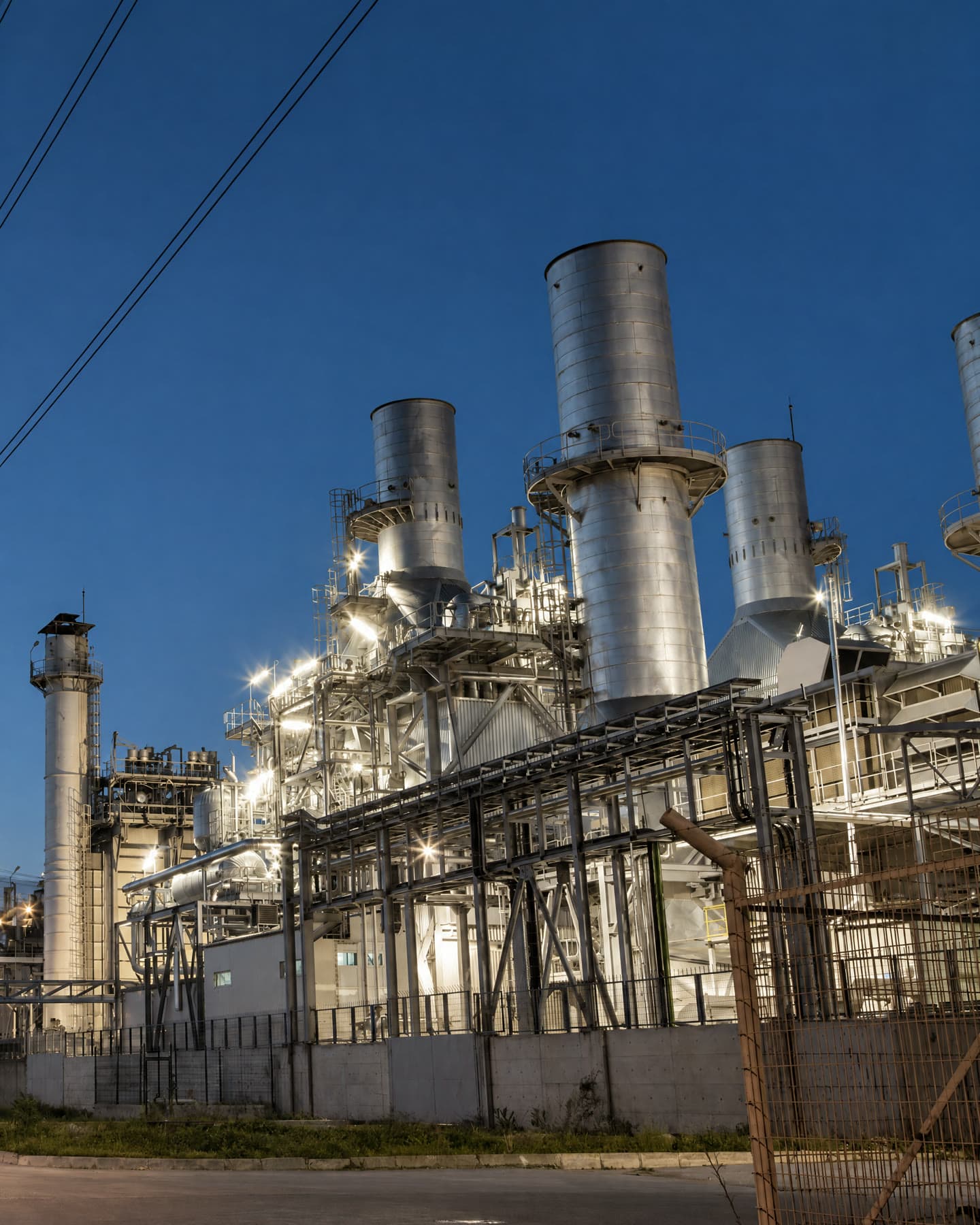 A power plant with tall exhaust stacks lit at dusk